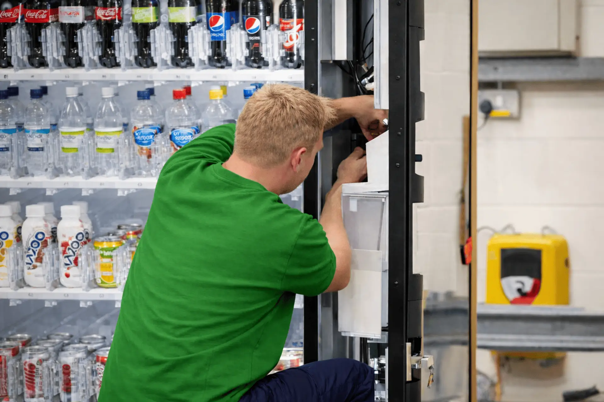 Serviser polni in vzdržuje vending avtomat z brezalkoholnimi pijačami